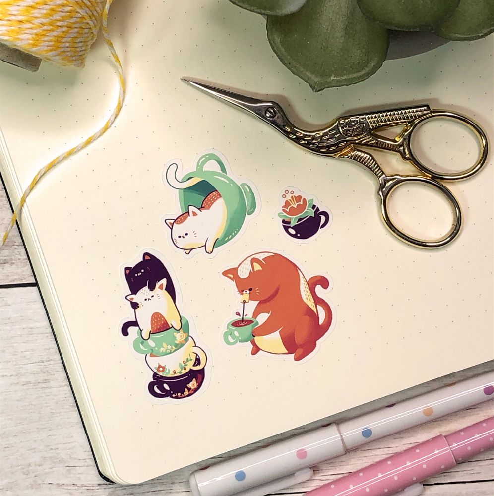 Cats and tea themed stickers displayed in a bullet journal. 