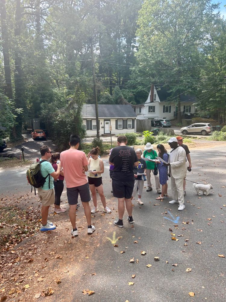 Group of walkers pausing to read info on paper packet 