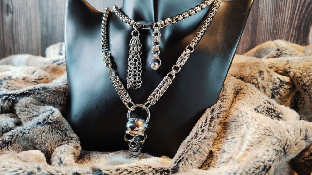 Gros collier inspiré de la série télé "the imperfects". C'est un long collier qui se croise derrière le cou et s'attache devant, donnant l'impression d'une chaîne à deux étages. Des petites chaînettes pendent un peu partout, et devant il y a un gros pendentif en forme de crâne humain.