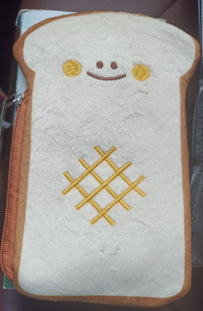 cute pencil case that resembles bread which is smiling 