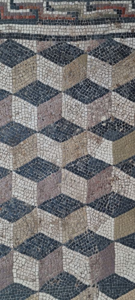 gut erhaltenes geometrisches Mosaik, dass durch Muster und Farbewahl die Illusion von Würfel erweckt