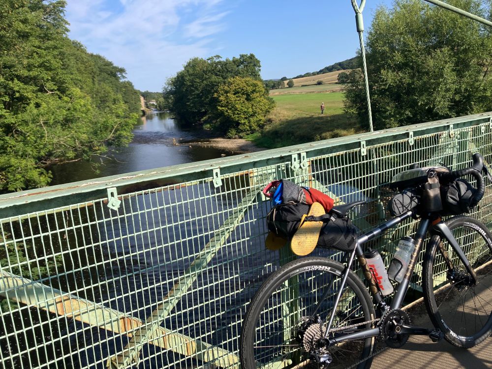 Picture of two wheeled cycle on bridge over river Aire