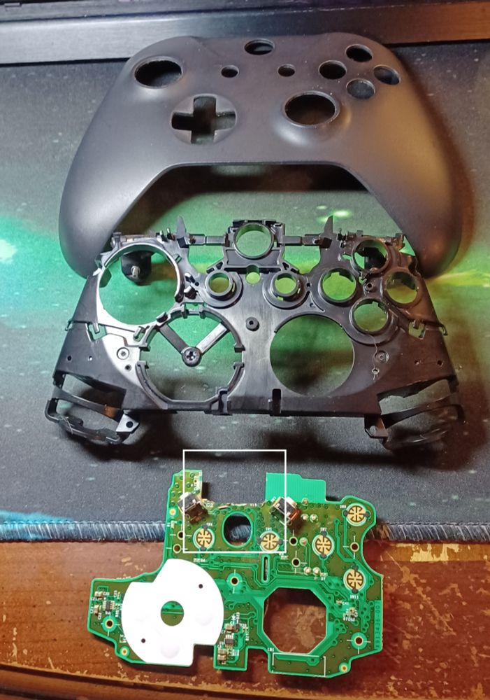 Parts of an XBOX One controller, the front shell, inner frame and hacked up pcb. Used to add a micro USB port to a PC Engine GT for a rechargable battery mod.