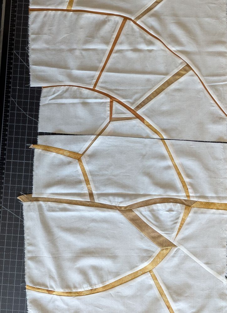 White fabric with gold lines sewn in