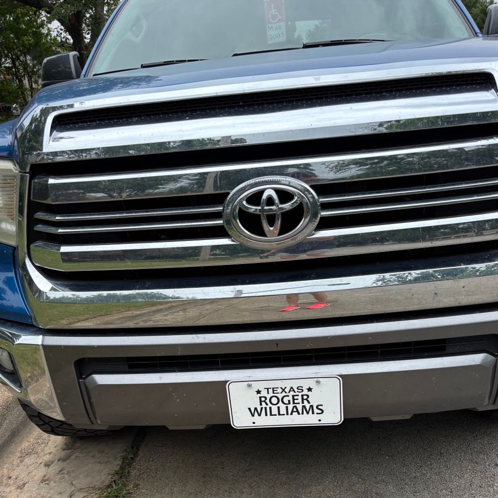 Front bumper of a big Toyota pickup with a Texas license plate that says “Roger Williams”