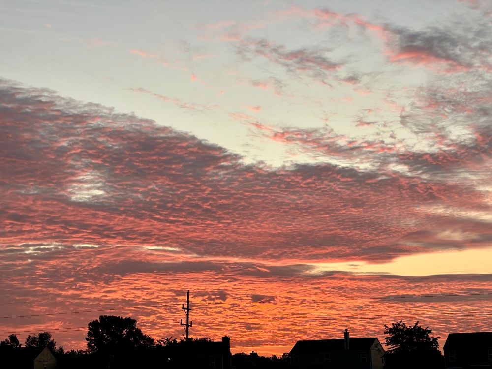 Grey and orange clouds against a blue and yellow sky 