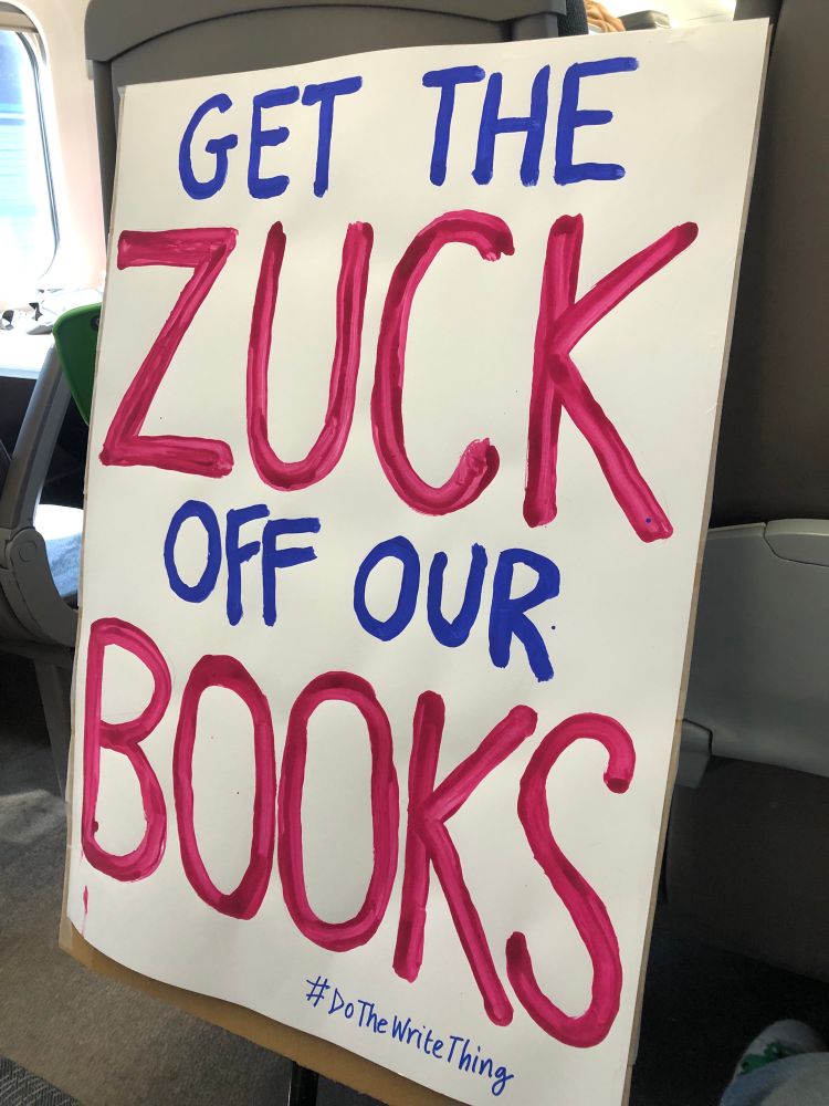 A hand-painted placard saying Get The Zuck Off Our Books