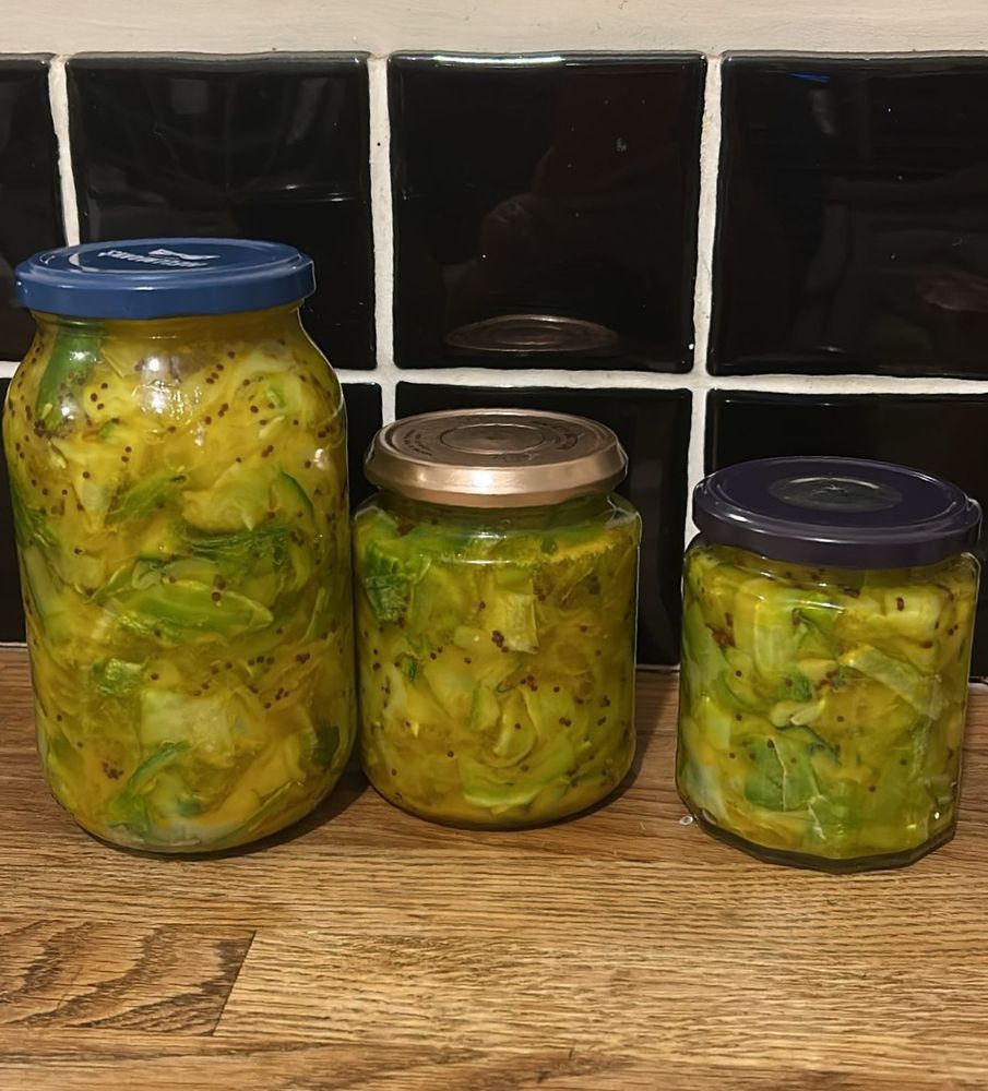 Three jars of homemade courgette pickles, pickled in apple cider vinegar and sugar with mustard and turmeric 