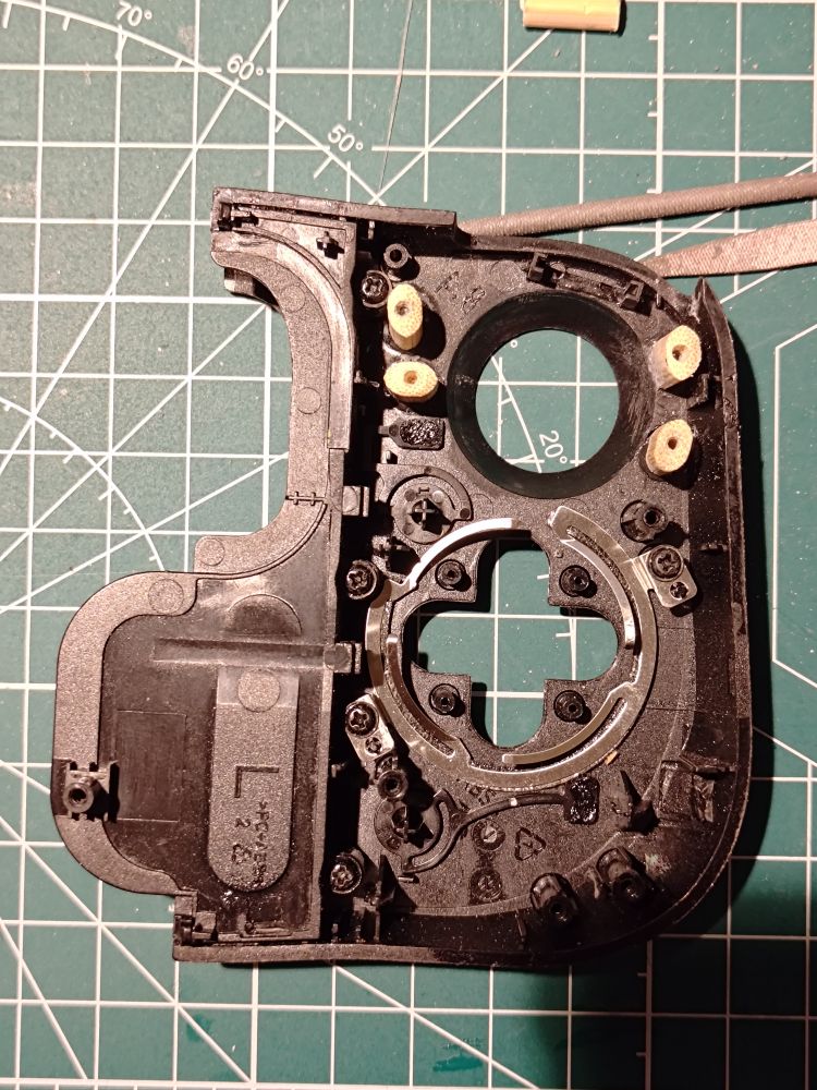 The inner side of a piece of a Razer Kishi controller, with four of the standoffs replaced by pieces of chopsticks. 