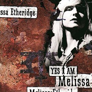 The cover of the Melissa Etheridge, Yes I am. Features a rusted background with a black and white picture of Melissa. Her name is in the top left corner and the bottom right corner has the album title and artist name again. 