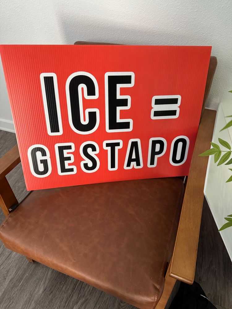 Protest sign, orange with black letters outlined in white that reads
ICE = Gestapo 