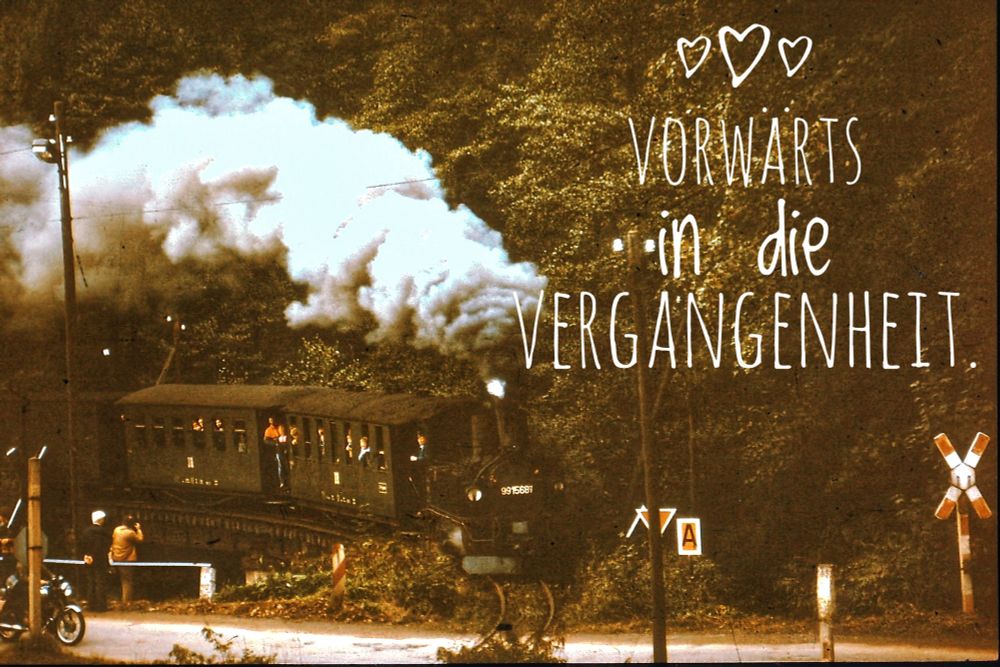 Das Bild zeigt eine Dampflokomotive mit Personenzug und den Schriftzug " Vorwärts in die Vergangenheit".