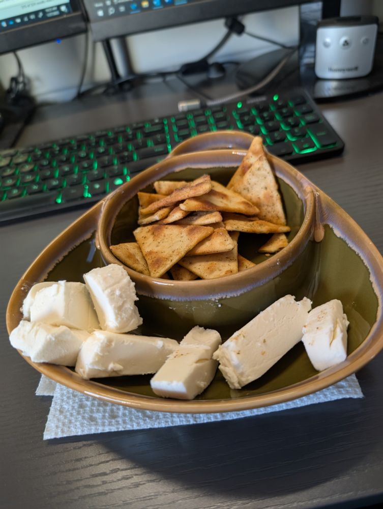 Chunks of goat cheese, in a divided bowl, with crackers