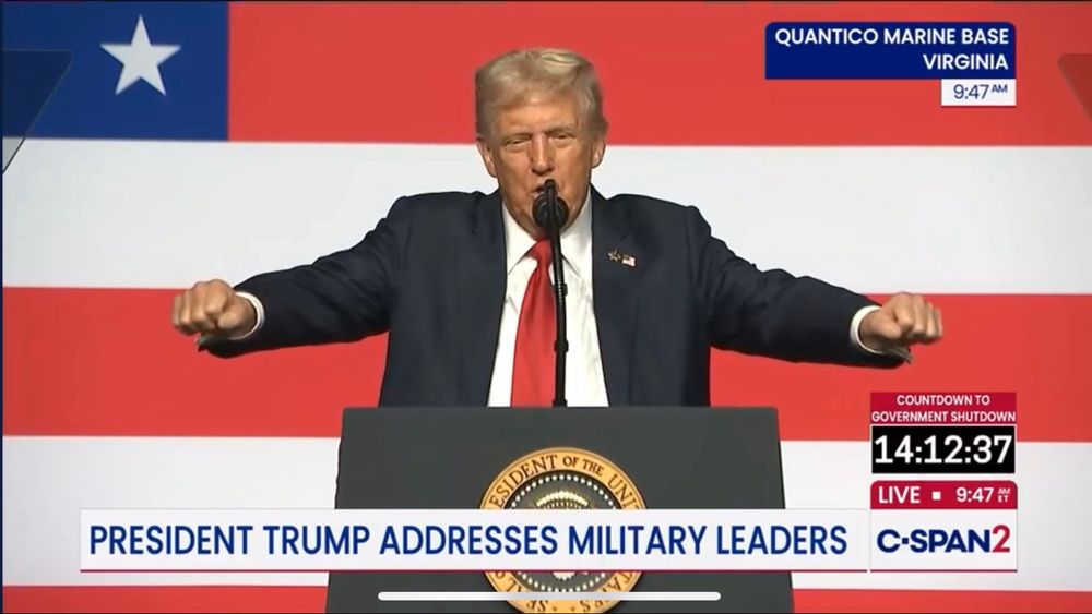 Trump with his arms outstretched as if milking two cows at the same time.