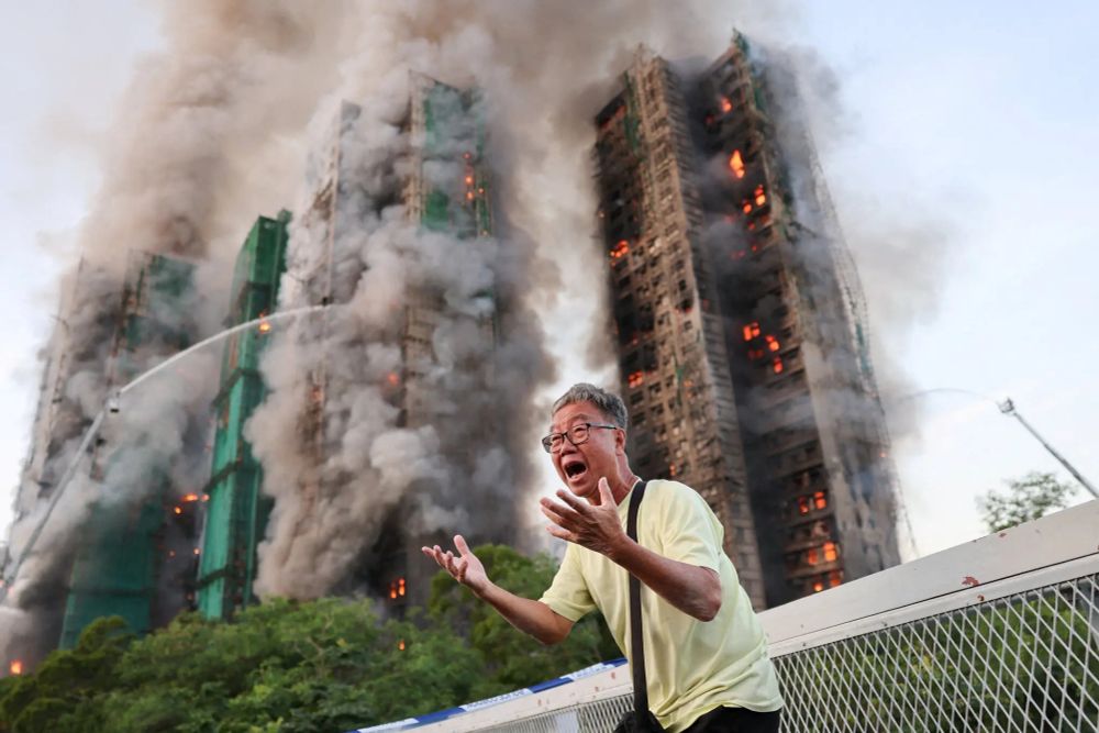 (Photo: Tyrone Siu/Reuters) A man reacts as smoke rises from flames engulfing bamboo scaffolding across multiple buildings at Wang Fuk Court housing estate, in Tai Po, Hong Kong, on Wednesday. (New York Times caption)