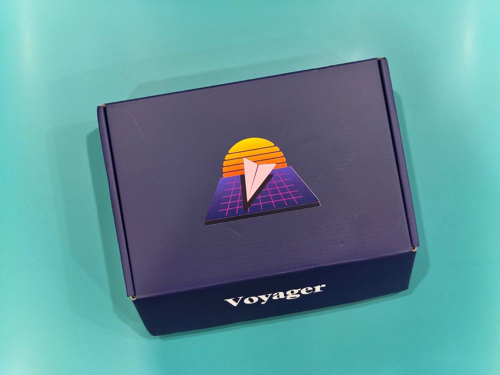 A purple box for the ZSA Voyager split keyboard, with 'voyager'written in white text on the front. 