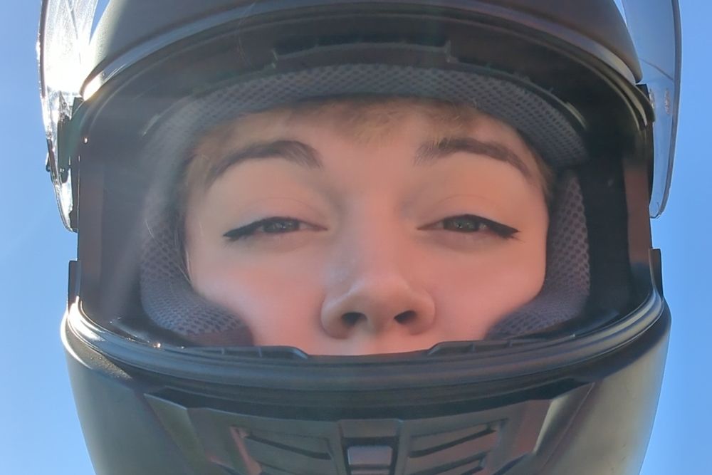 my face in a motorcycle helmet, sky in the background. only my eyes and nose are visible