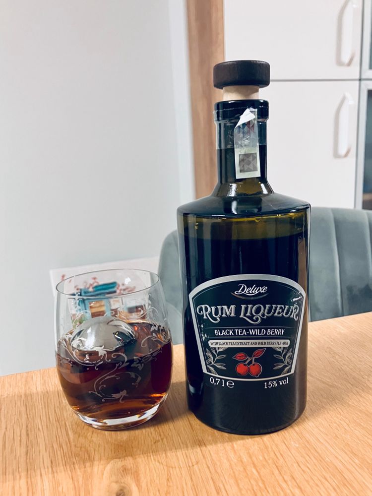 Black tea wild berry rum liqueur served over ice with Angostura bitters