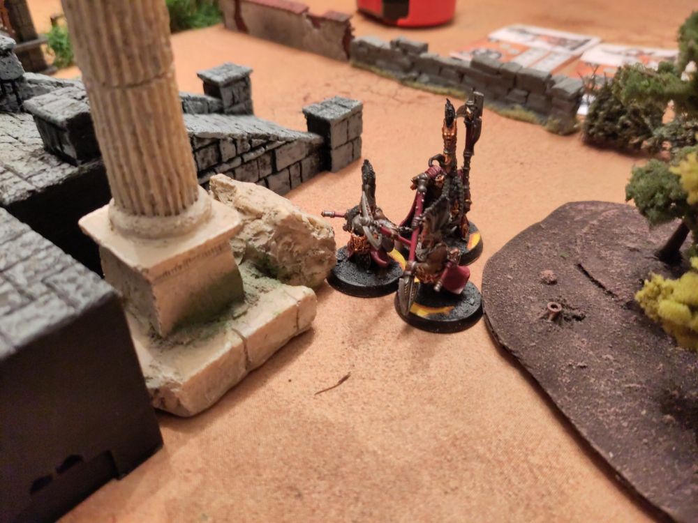 Three Fyreslayer tabletop miniatures between some scenery.