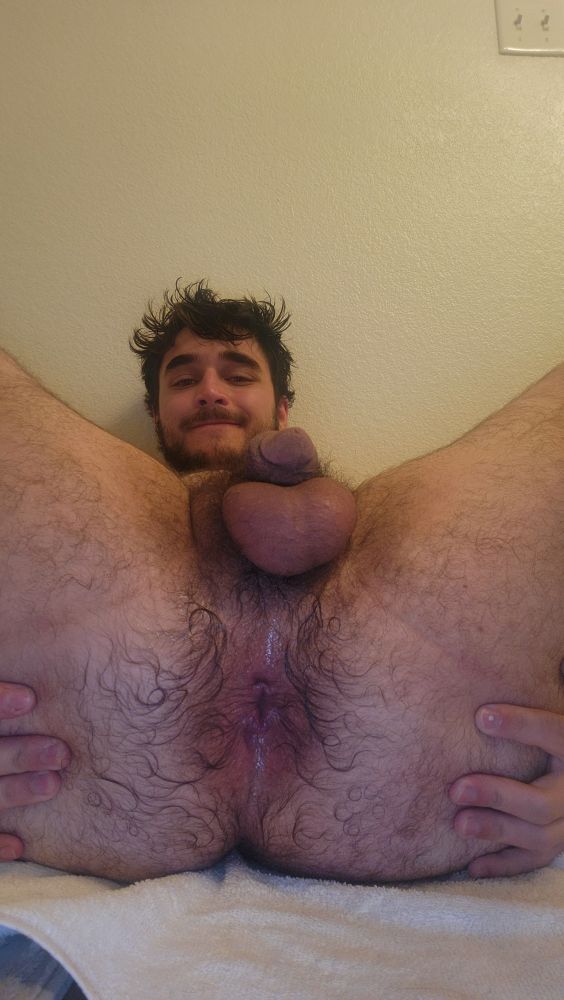 Picture of a hairy man slighly smiling and showing off his wet hairy cheeks