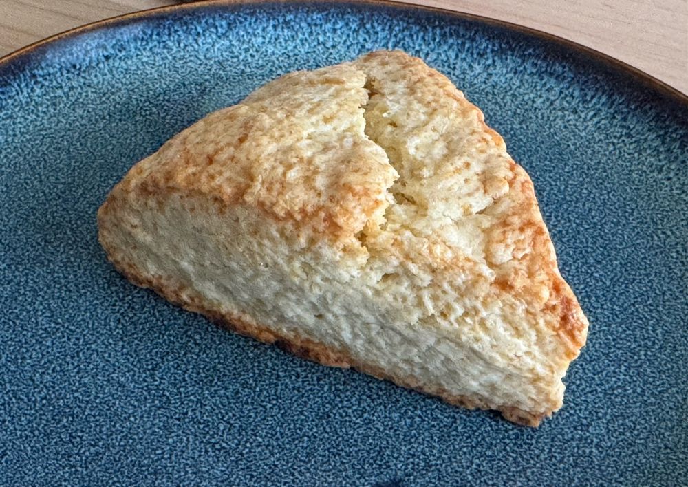 A delicious scone on a blue earthward plate.