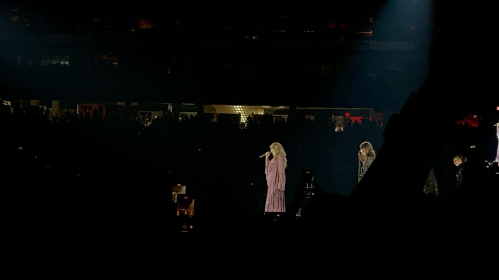 Taylor on the first night of the eras tour wearing the purple folklore dress.
