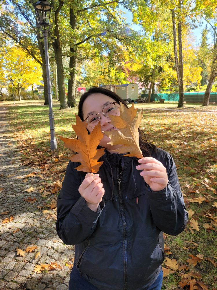 Me holding up two big orange leaves in front of my face
