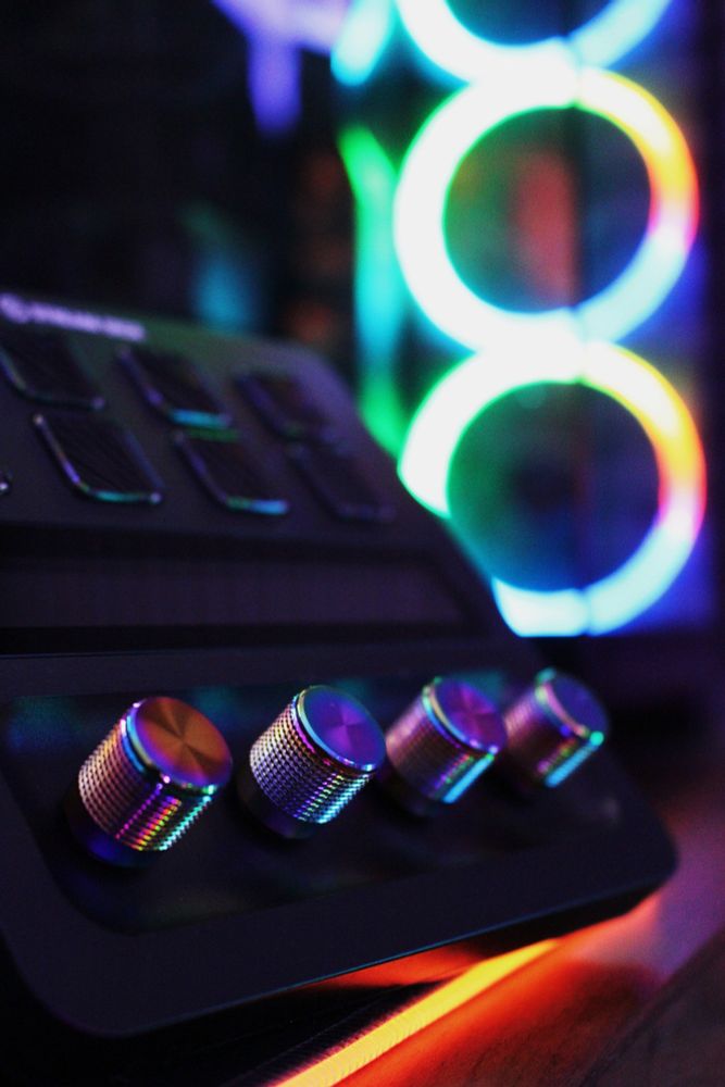 Close up on the Elgato Stream Deck + cosmic dials with PC RGB fans in background 