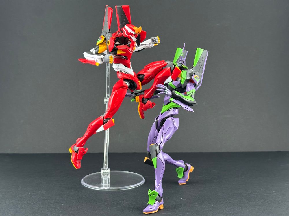 The Real Grade Evangelion Unit 01 and 02 posed together. The Unit 02 is delivering a jumping knee to the Unit 01.
