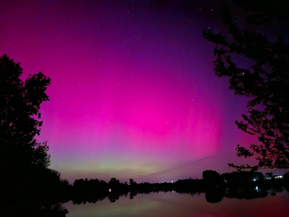 Ein glücklicher Zufall bescherte uns dieses Foto. Durch die Kamera erscheinen die Polarlichter noch intensiver.
Das seltene Naturschauspiel hängt eng mit unserer Forschung in den Sektionen „Geomagnetismus“ und „Weltraumphysik
und Weltraumwetter“ zusammen.
Polarlichter entstehen, wenn Teilchen des Sonnenwinds mit Atomen und Molekülen in der Atmosphäre zusammenstoßen
und sie zum Leuchten anregen. Normalerweise treten sie in Ovalen von rund 3.000 bis 4.000 km Durchmesser
um die Pole auf. Das ist in Europa in Nordskandinavien der Fall. Nur selten – bei sehr starker Sonnenaktivität
– erreichen sie niedrigere Breiten wie hier bei Bamberg am 10. Mai 2024 um 23 Uhr. Denn das im Erdkern
erzeugte Erdmagnetfeld bildet einen sehr effektiven Schutzschild um die Erde: die Magnetosphäre.
So schön das Leuchten ist: Für unsere hochtechnisierte, von Satelliten abhängige Gesellschaft können die
geladenen Teilchen und elektromagnetischen Felder des Sonnenwindes auch zerstörerische Auswirkungen
haben. Satelliten können beschädigt werden, GPS-Systeme den Dienst versagen. Selbst unsere Stromnetze
können betroffen sein, wenn uns ein besonders starker geomagnetischer Sturm erreicht. Ein genaues Verständnis
der Magnetosphäre und Grundlagenforschung für zuverlässigere Weltraumwetter-Vorhersagen
sind daher unerlässlich. Foto: Monika Korte