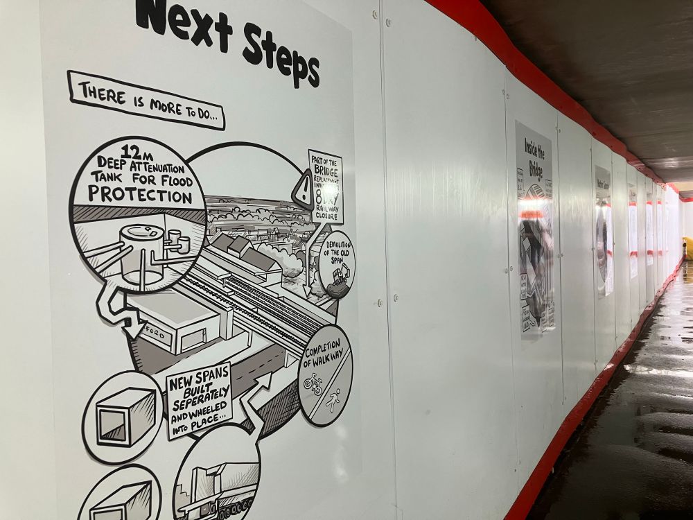 Public art in comics style, explaining the works relating to the Botley Road closure for infrastructure improvements to the railway bridge and associated elements. The panel that’s visible is titled ’Next Steps’; other panels have titles such as ‘Welcome to West Oxford’ or explain the complexity of the super sewer works underneath. The panels are smaller than the wall space available, and there is a lot of white space in between each set of panels.