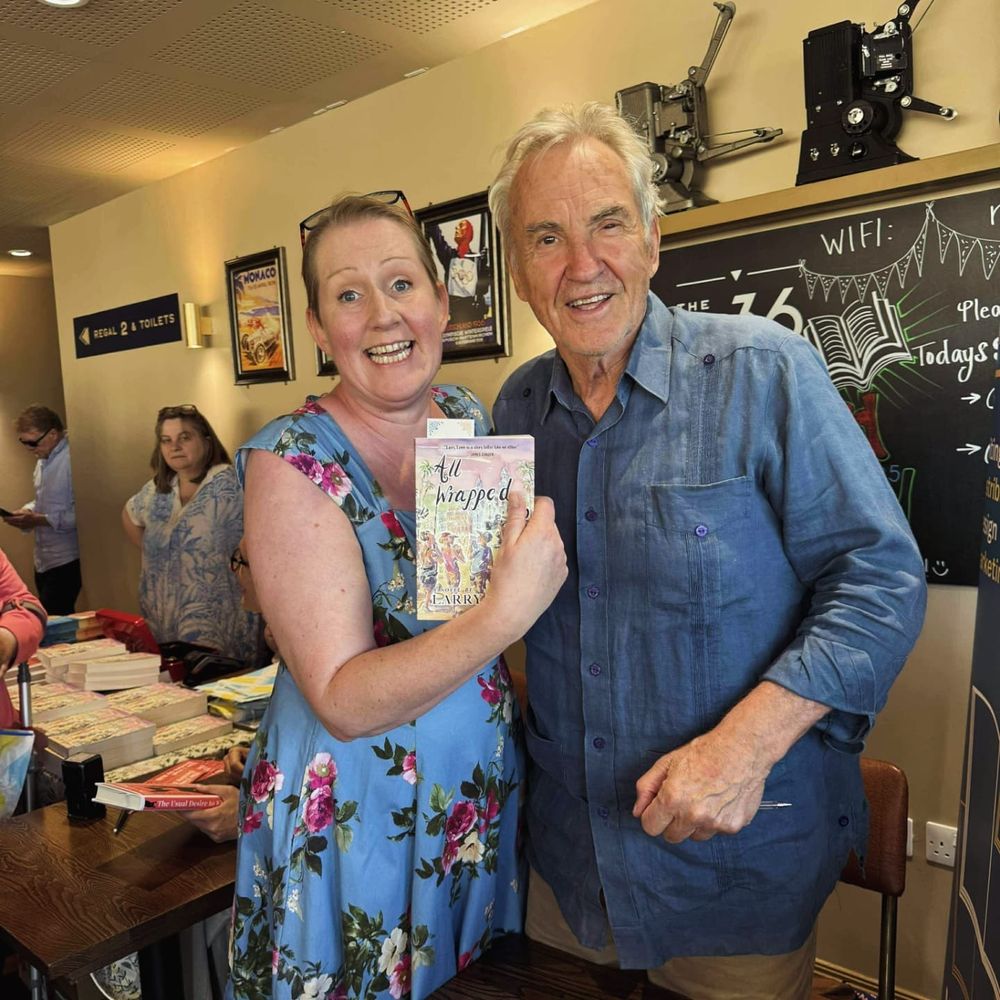 Jenni Keer with Larry Lamb.  Jenni is holding up a copy of his book