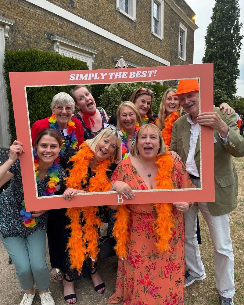 A handful of authors and the incredible Amanda Ridout posing in a photo frame outside Fulham palace