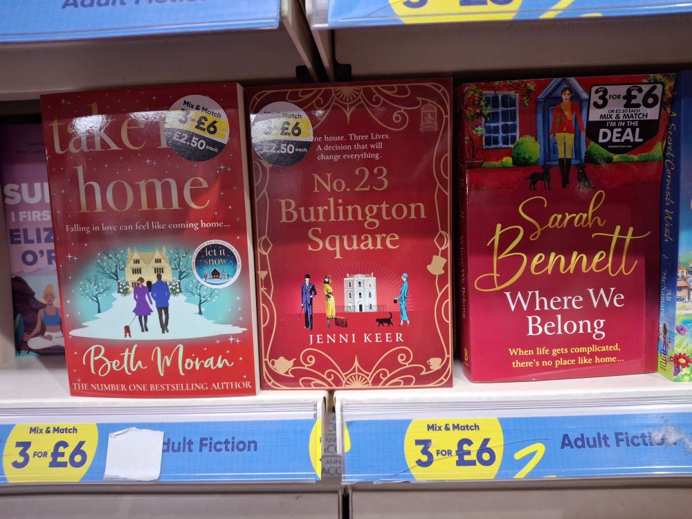 Three bright red books on a shelf: Take me Home, No. 23 Burlington Square and Where we Belong 