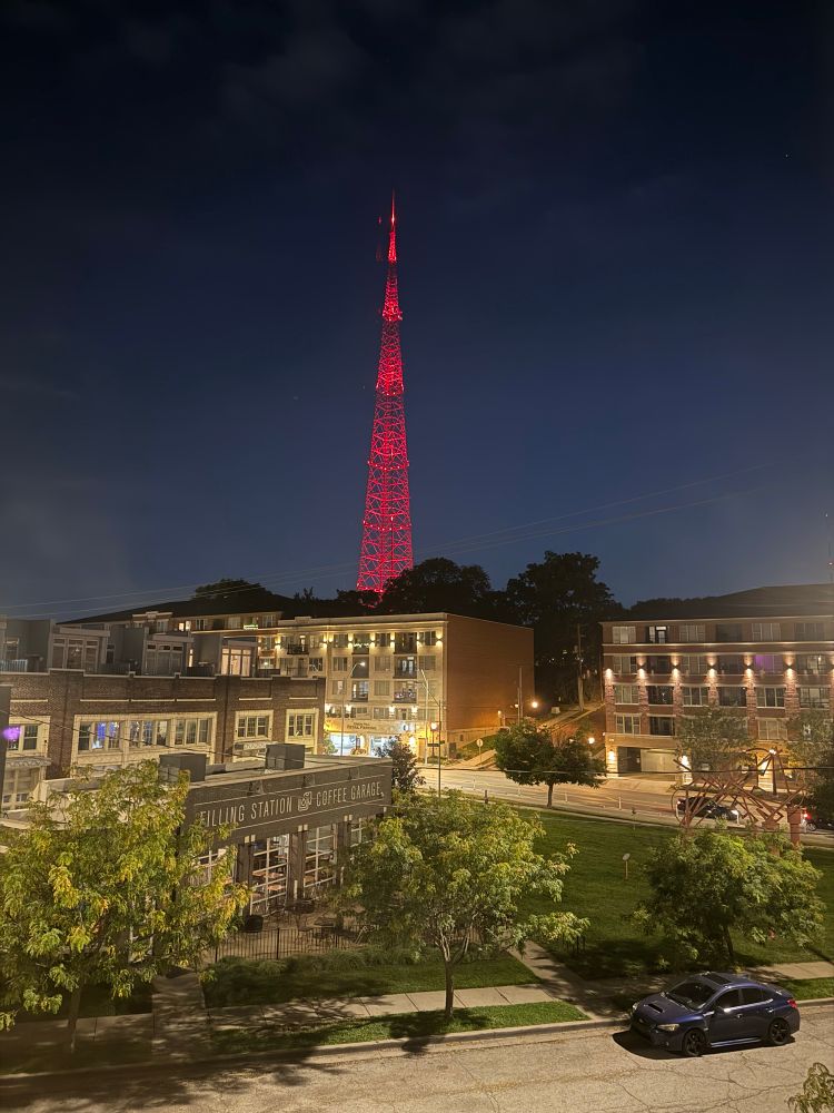 Tall TV broadcast tower lit up with red lights