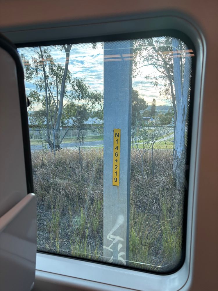 Distance marker on an electrified railway catenary pole reading “146.219” indicating the pole is 146.219km from Sydney Central. 