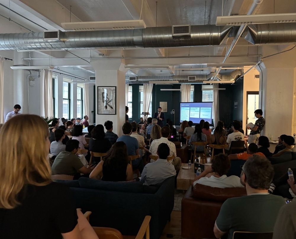Group of attendees gathered at an AI governance discussion event in New York City, hosted by BlueDot Impact, AI Safety Awareness Project, and NYC AI Safety. People are seated and standing, engaging in conversation about responsible AI development and the RAISE Act.