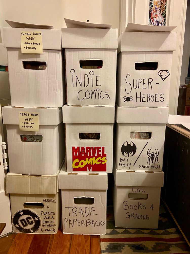 9 large comic book boxes stacked on top of each other. They have a variety of labels such as Marvel, DC, Trade Papers, and Indie Comics