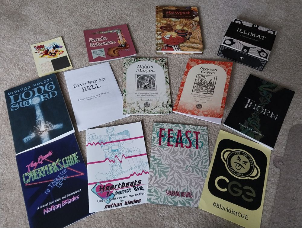 The haul:
-Scritch Claw by Adam Vass
-Bonds Between by Jon Boyle, Bri de Danann, Emily Entner, and Lucas Zellers
-Stewpot by Takuma Okada
-Illimat by Keith Baker
-Long Sword by Viditya Voleti
-Dive Bar in HELL by Seren Briar
-Hidden in the Margins + Between the Covers by Seb Pines and Will Jobst
-Thorn by Spencer Campbell
-The Queer Cyberpunk's Guide to Tabletop RPGs + Heartbeats in Perfect Sync by Nathan Blades
-Feast & Verdure by Sharang Biswas
-#BlacklistCGE by Marceline Leiman
