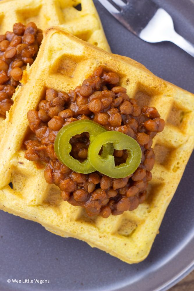 Close up shot of barbecue lentils on cornbread waffles with jalapeño slices on top. 