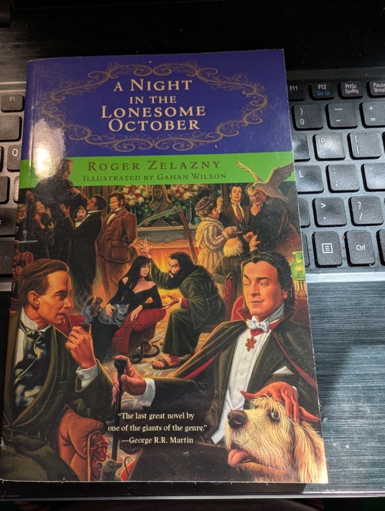 The cover of a paperback novel called A Night In Th Lonesome October, by the late Roger Zelazny, and illustrations by Gahan Wilson. 

The cover group of people are gathered in a lounge for some type of get together. In the foreground, a man in a dinner jacket and smoking a pipe speaks to a gentleman in a black tuxedo and red-lined opera cape sporting a prominent set of fangs who rests one hand on a cane, and the other to pet a large sheepdog. A rat's head pokes up curiously between the two. 

Past them, a woman in a black dress with a cat on her lap reclines one a loveseat while a wild-eyed man with a bushy beard in a black robe and sandals speaks excitedly to her, waving his arms as he speaks. A scythe rests on the mantle behind them, and a snake coils around the legs of the loveseat while a squirrel perches next to the woman. A hairy gentleman with prominent canines can just be seen sitting in a chair behind the gentleman smoking the pipe. 

On opposite ends of the fireplace, a group of people are gathered around Frankenstein's Monster in interest while Victor Frankenstein seems to be speechifying. Across from them, a plump woman in a fur coat is speaking with three gentlemen, a diminutive man with a long nose and a shock of white hair, another who is raising a wine-glass in celebration, while the third man is giving a calculating look at the white bird perched on his shoulder, stretching its wings.

At the bottom of the cover there is an endorsement from George R.R. Martin, who writes "The last great novel by one of the giants of the genre".
