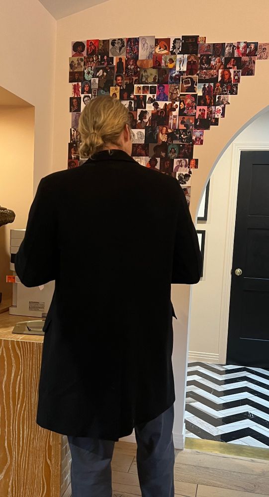 Sam Reid looks at the left section of the fan art wall in the Writer’s Room Office. 