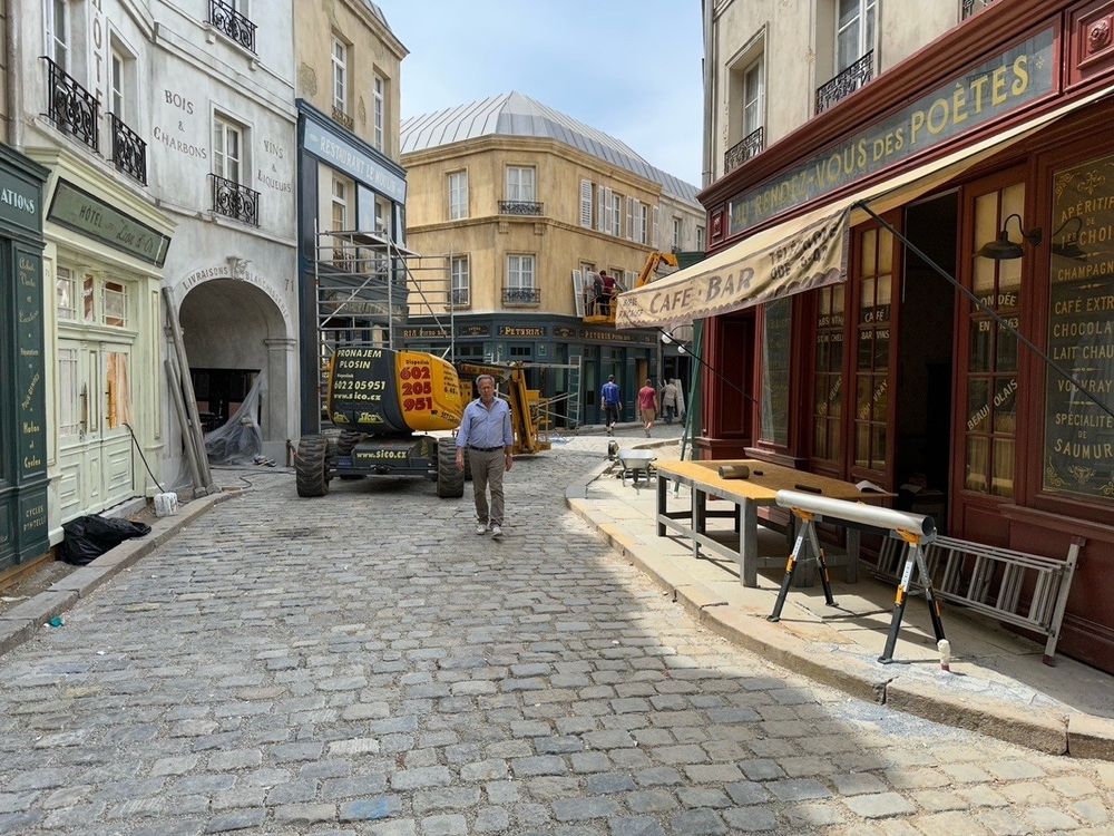 Exec Producer Mark Johnson walks down the street of our Parisian backlot towards the camera, as construction equipment and scaffolding lines the street further down.