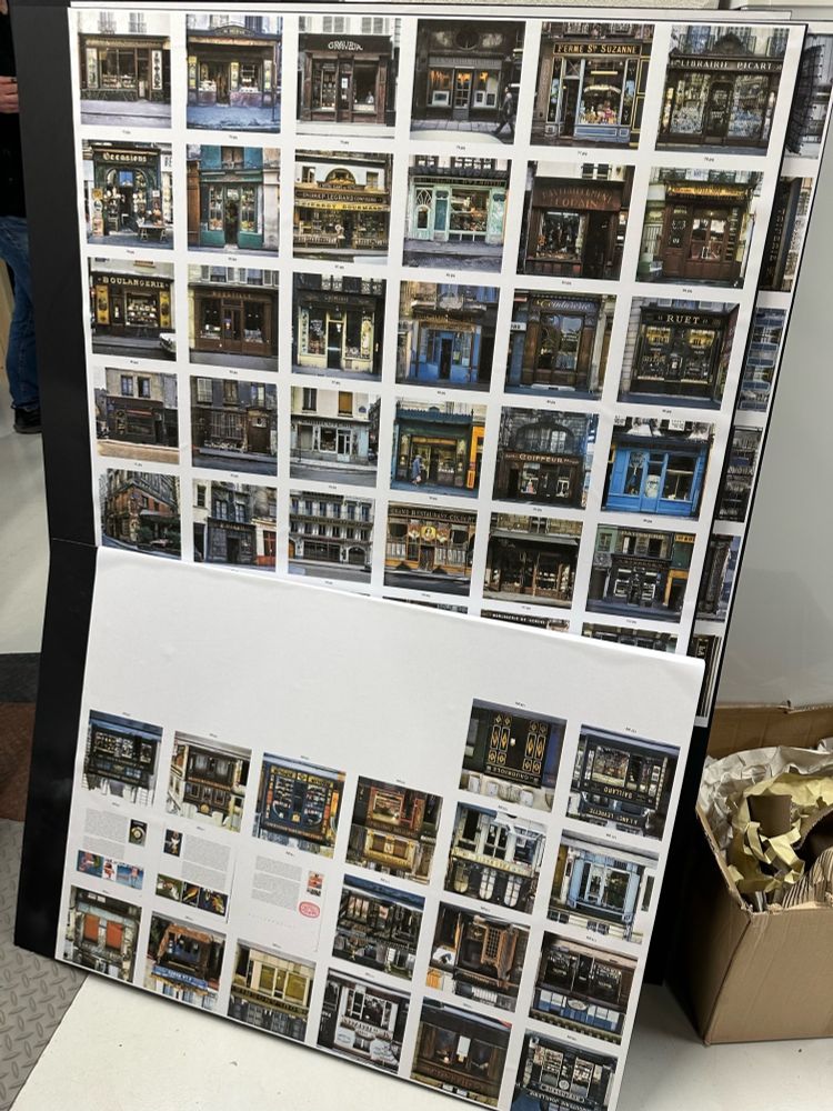 A white board with reference photos of Parisian storefronts from the time that correspond to each backlot exterior.