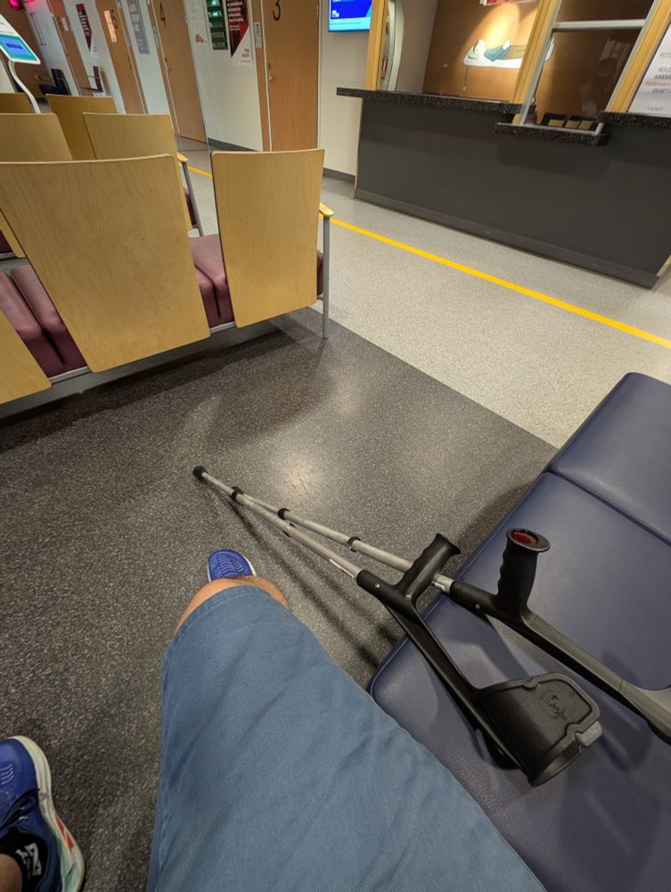 My bum knee next to crutches in a hospital waiting area.