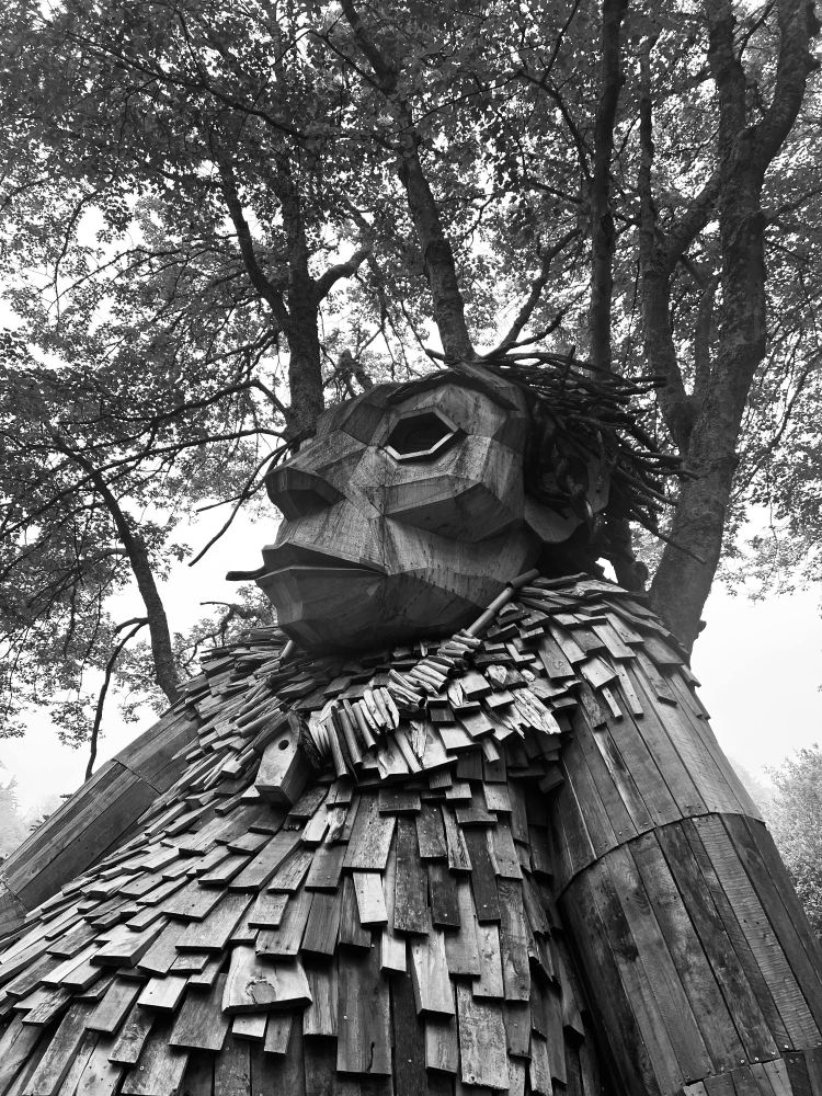 A black and white photo of Erik Rock, a troll sculpture made by Thomas Dambo in Rhode Island.