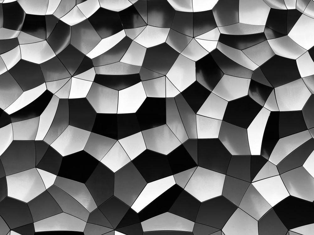 A black and white photo of a geometrically textured wall.