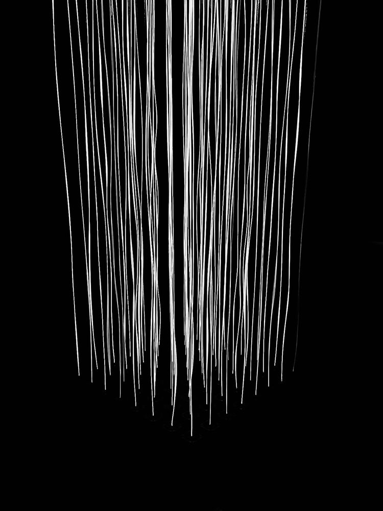A black and white photo of white light strings falling down from the top of the ceiling from the Mattress Factory in Pittsburgh, PA.