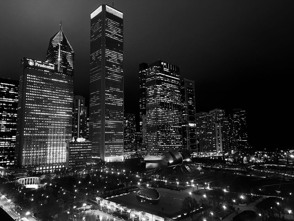 A black and white photo of the Chicago skyline at night.