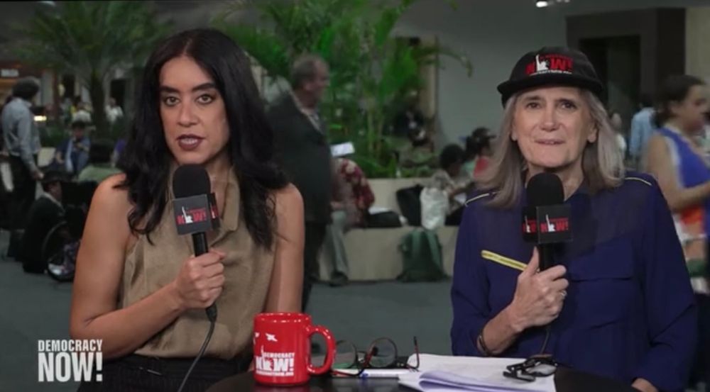 LIVE! screenshot of last day at COP 30 ..... Nermeen & Amy sitting at the broadcast table outside the event ... Nermeen is speaking